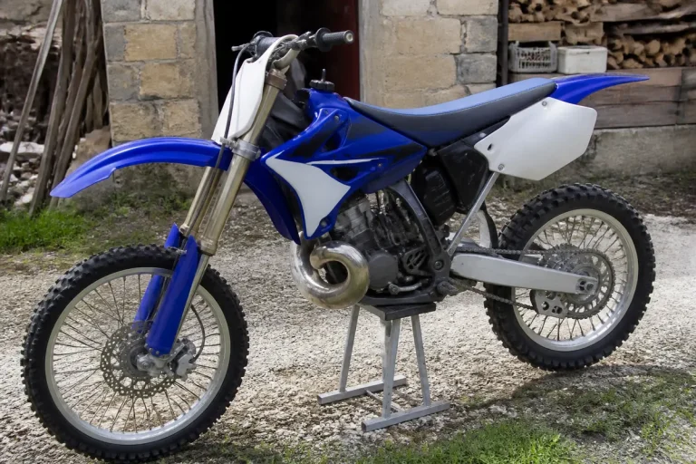 Moto cross bleue 125 YZ de l'année 2000 en extérieur sur béquille.