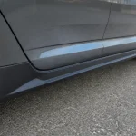 Vue rapprochée du bas de caisse d'une voiture sur une route asphaltée