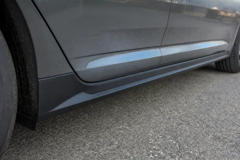 Vue rapprochée du bas de caisse d'une voiture sur une route asphaltée