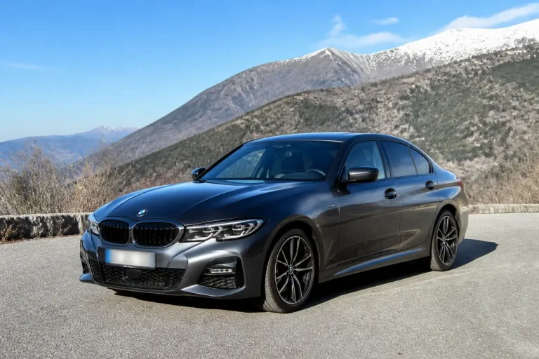 Voiture BMW M Sport grise sur route montagneuse par temps clair