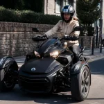 Conductrice sur un tricycle motorisé Can-Am avec casque sur route ensoleillée.