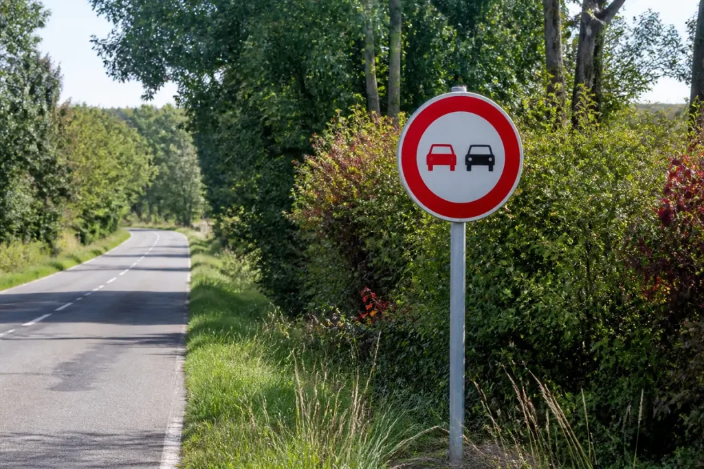 Panneau d'interdiction de dépasser sur route campagne pour test des panneaux du code.