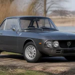 Voiture classique grise de la Lancia Fulvia Coupé sur une route de campagne