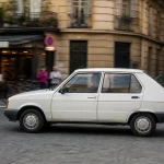 Voiture Citroën Visa blanche roulant dans une rue animée en ville