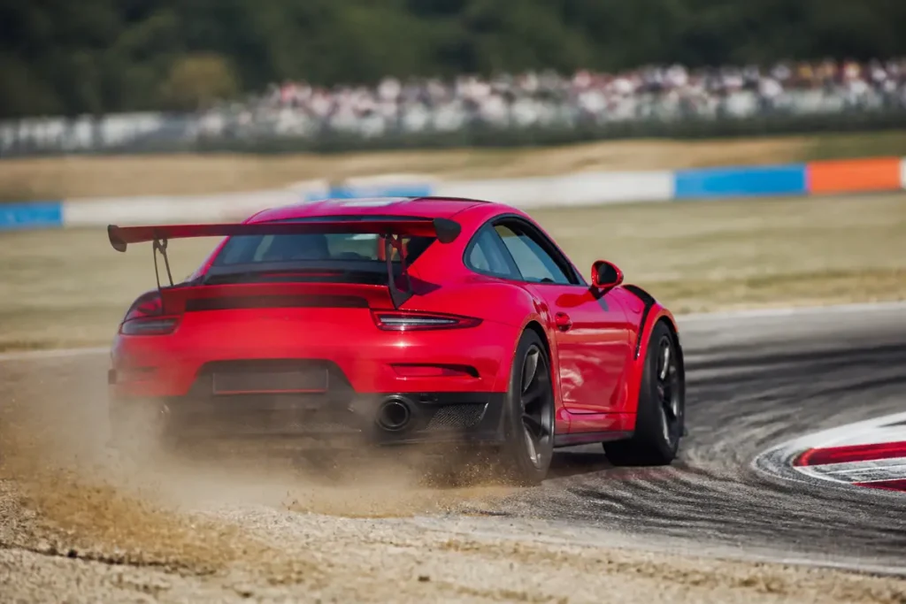 Voiture rouge prenant un virage sur circuit lors d'un stage de pilotage Tous En Bagnole